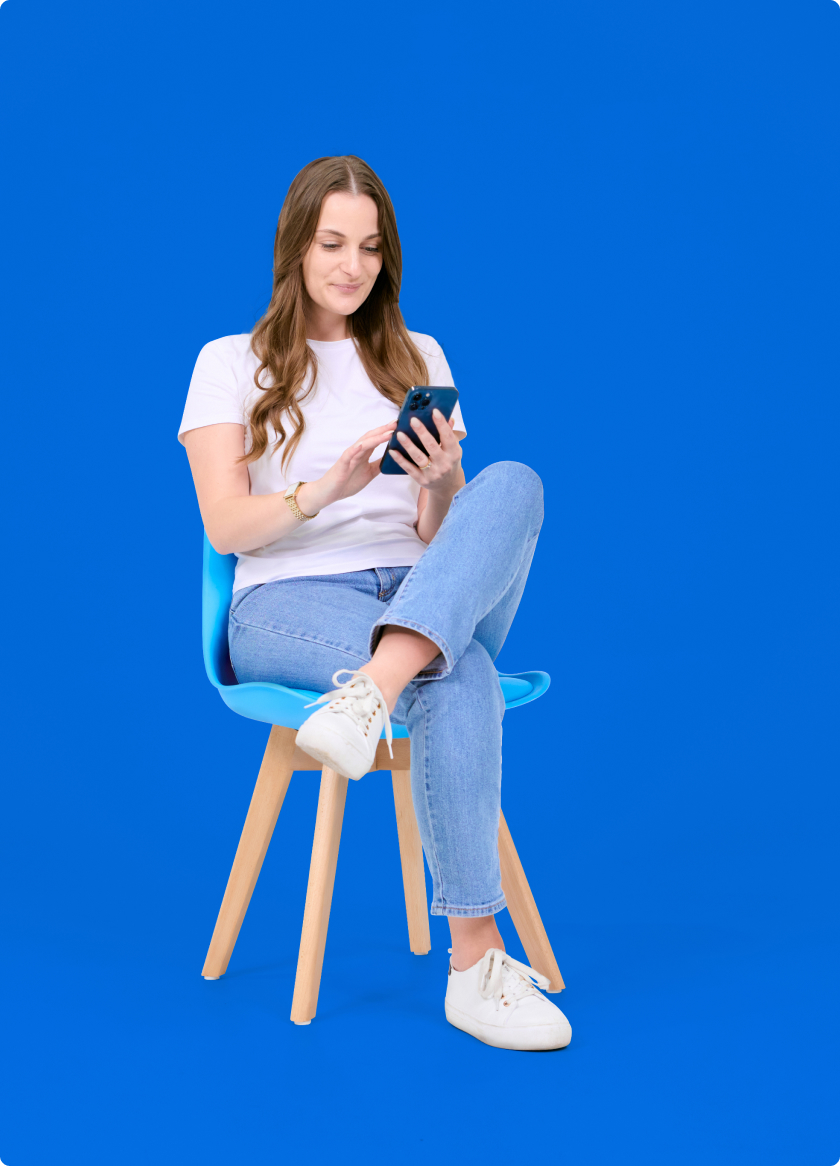 form-img-tablet A young woman sitting on a chair and using a cell phone.