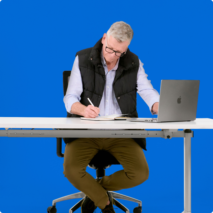 business-operations-img A man sitting at a desk with a laptop.