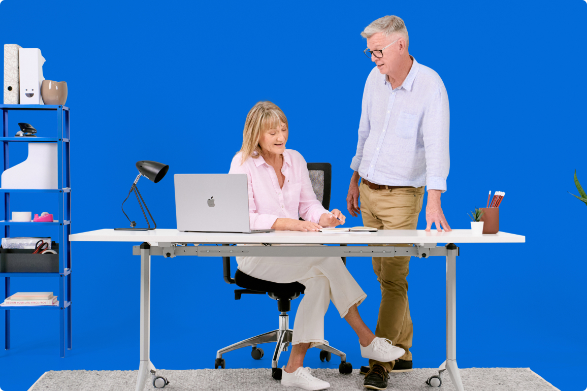 business-solution-img1 A man and woman standing at a desk.