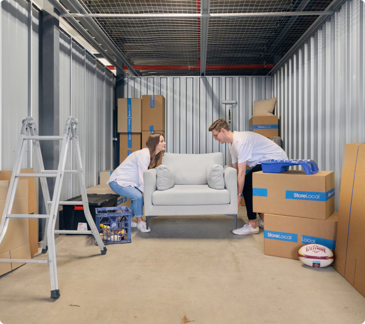 move-in-img2 Two people moving a couch into a storage room.