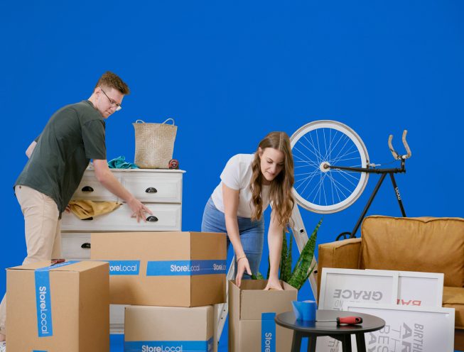 storage-type-banner-bg-mobile A man and woman moving boxes on a blue background.